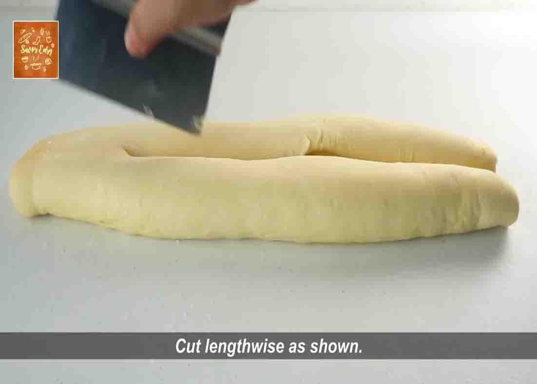 Cutting the almond cream bread dough in half