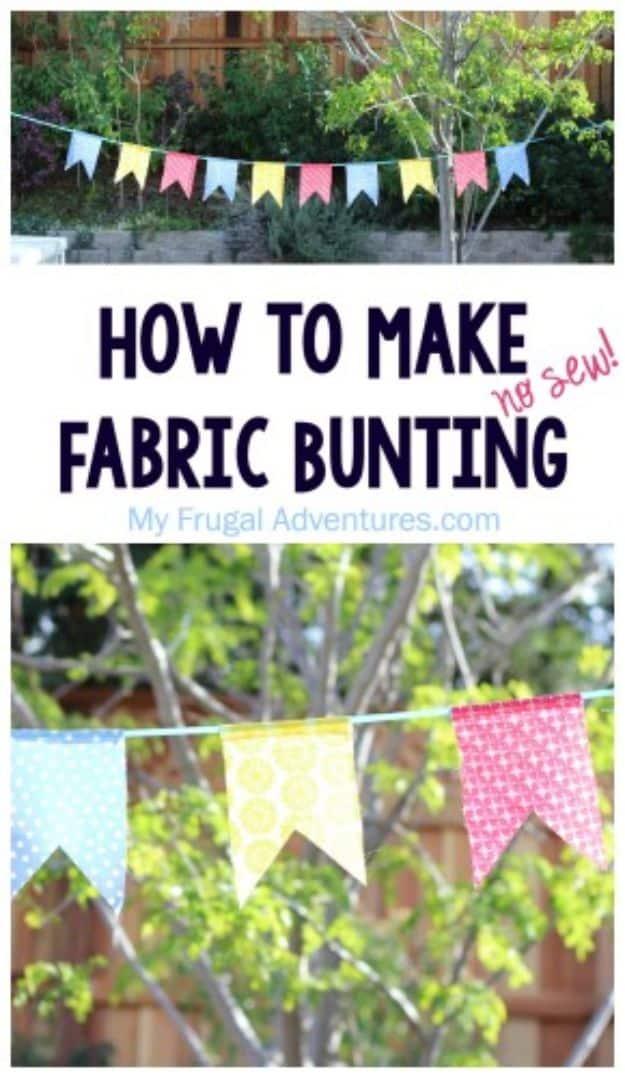 No sew fabric bunting in blue, yellow and pink prints, notched flags strung on green twine outside in a garden