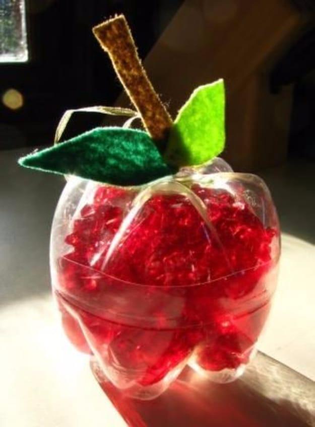 Hanging apple decoration made from two plastic bottle ends filled with red cellophane, with green felt leaves