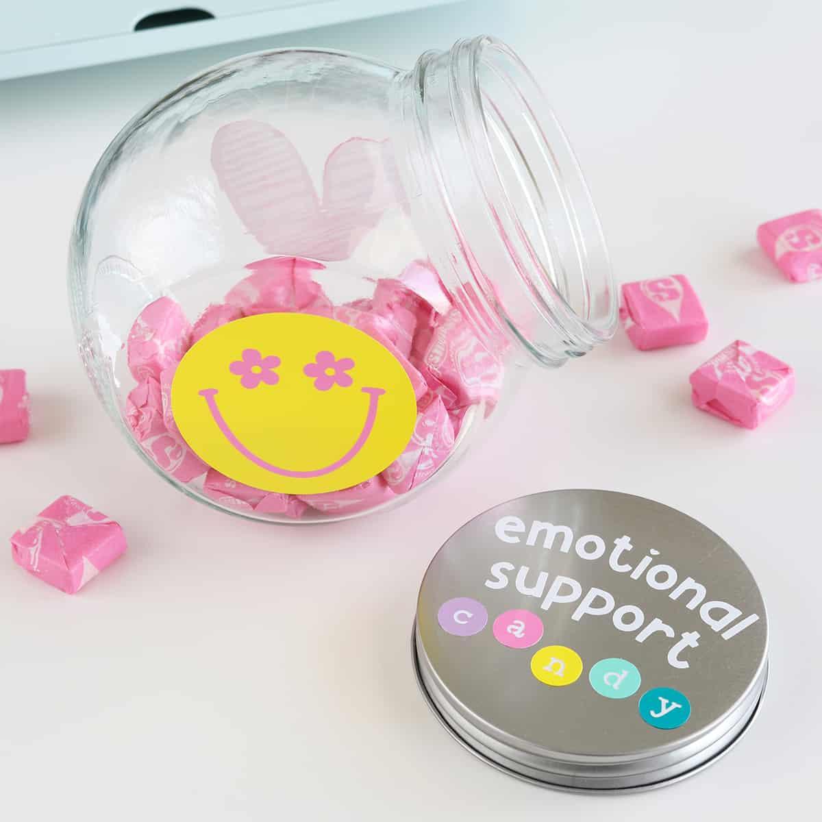 Clear dollar store glass jar with a vinyl emotional support candy label, filled with brightly wrapped sweets