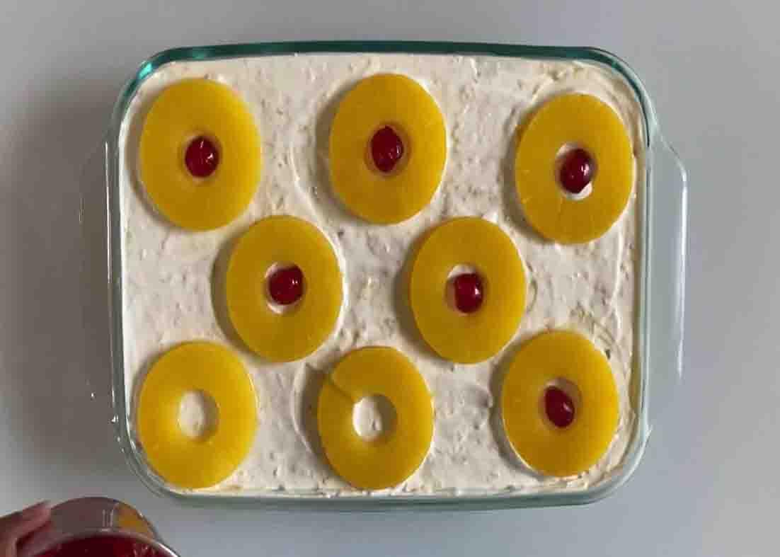 Topping the pineapple whip dessert with some pineapple slices
