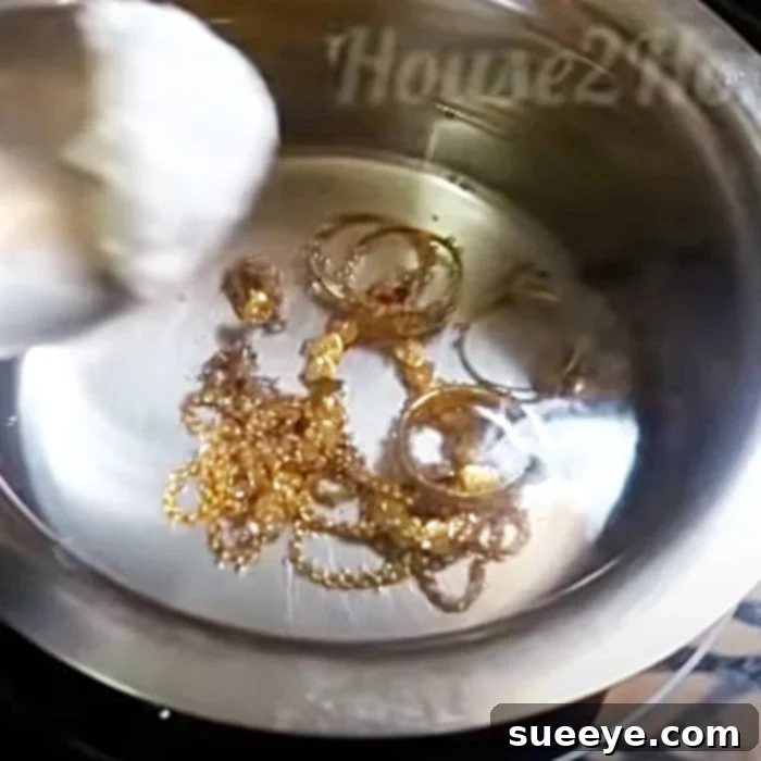 Gold Revival: Simple At-Home Jewelry Cleaning 2 Gold jewelry simmering in a pot of boiling water with baking soda, illustrating the initial cleaning stage.