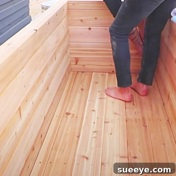 Build Your Dream Wooden Hot Tub From 2x6s 3 A completed wooden hot tub with internal benches and visible plumbing connections.