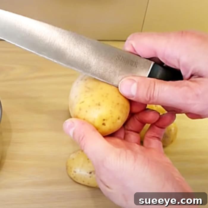Effortless Spud Cleaning Method 2 A hand demonstrating the circular cut around a potato.