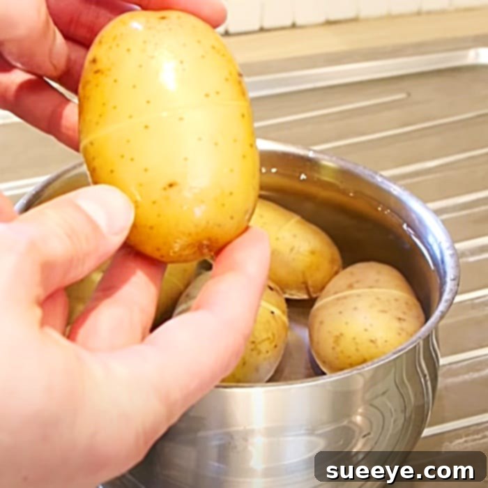 Effortless Spud Cleaning Method 3 A hand easily peeling the skin off a potato after the hack.