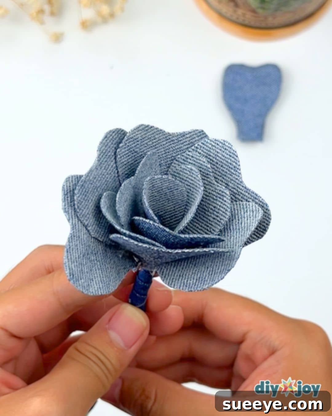 How to upcycle old denim jeans: attaching medium-sized petals