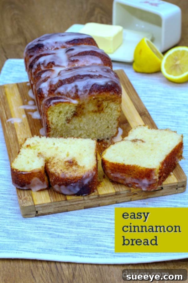A golden-brown loaf of Dolly Parton's famous cinnamon bread, perfectly baked with a glistening glaze and inviting swirls of cinnamon sugar, on a rustic wooden surface.