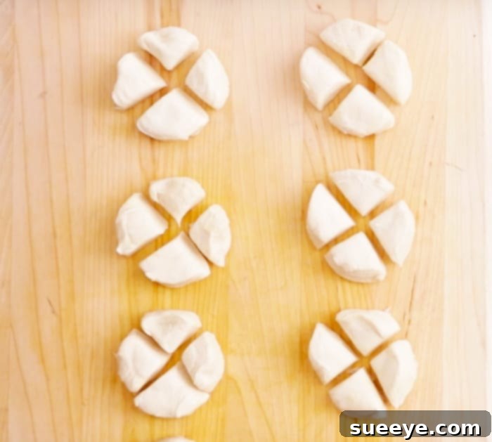 Quick Cinnamon Sugar Monkey Bread 2 Step-by-step guide on how to prepare Pillsbury biscuits for the Cinnamon-Sugar Pull Apart Loaf, showing dough separated and cut into quarters, ready for coating.