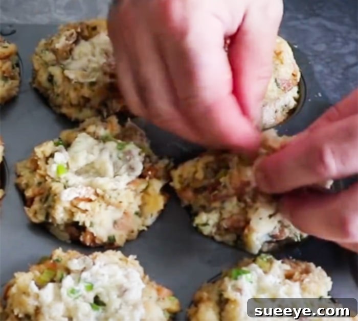 Stuffing Muffins with a Gravy Core 3 How To Make Gravy Stuffed Stuffings - Muffin Recipes - Savory Muffins. A close-up image showing the process of filling a muffin tin with stuffing, making a well, and adding chilled gravy before sealing.