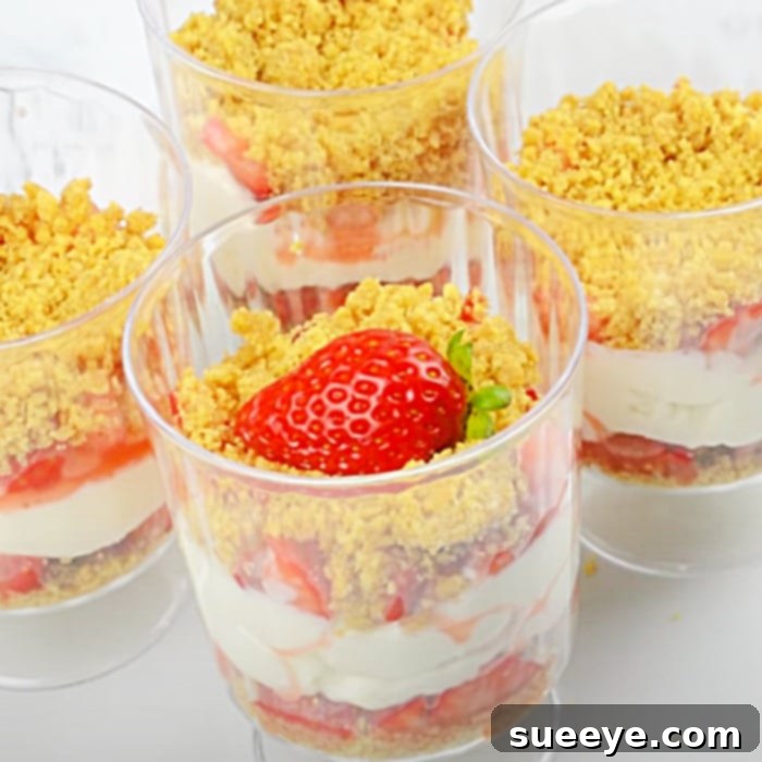Easy No-Bake Strawberry Cheesecake Cups 3 Close-up of a beautifully garnished individual no-bake strawberry cheesecake dessert cup, ready to be served.