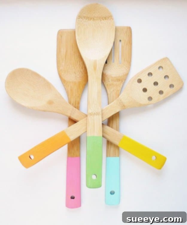 DIY Color Dipped Wooden Kitchen Utensils for a Fun Pop of Color Set of wooden kitchen utensils with colorful painted handles, displayed in a holder