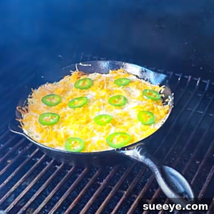 Sizzling Jalapeno Cheese Dip 2 Smoked Cheesy Jalapeno Skillet Dip in a cast iron skillet on a smoker