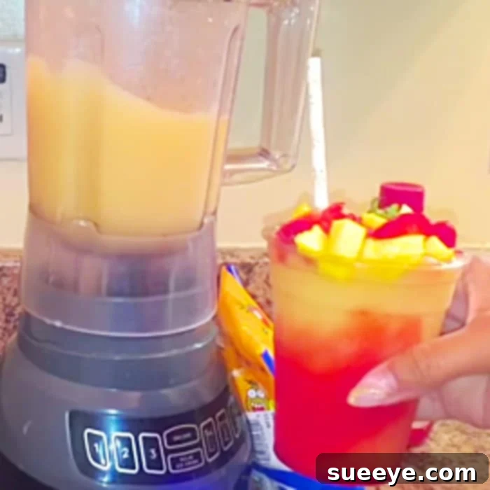 Boozy Jolly Rancher Hennessy Slush 3 A second vibrant frozen cocktail, possibly of a different flavor, in a similar clear glass, reinforcing the visual appeal of the Hennessy Jolly Rancher Freeze recipe.
