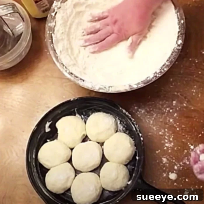 Freshly cut biscuit dough arranged in a cast-iron skillet, ready for baking.