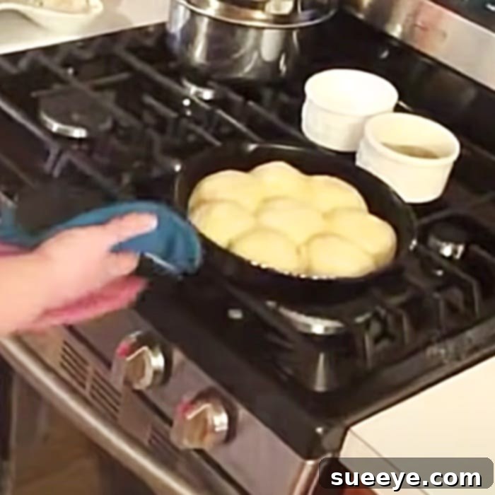 Freshly baked country-rolled biscuits in a cast-iron skillet, golden brown and fluffy.