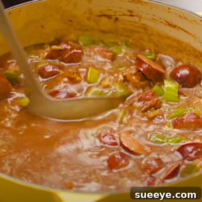 Authentic Chicken and Sausage Gumbo 3 The gumbo simmering in the pot, rich and flavorful, nearing completion.