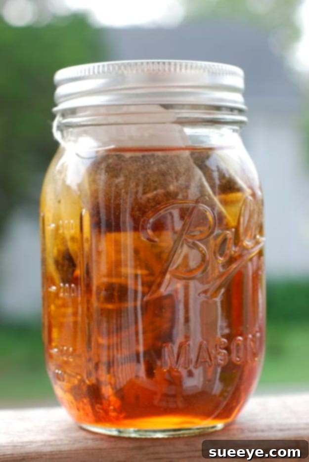 Effortless Simple Sun Tea: Naturally Brewed Refreshment Simple Sun Tea brewed in a large glass jar, sitting outdoors.
