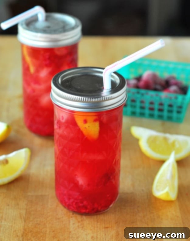 Fruity Raspberry Sun Tea: A Naturally Sweet Summer Brew Raspberry Sun Tea in a mason jar, garnished with fresh raspberries.