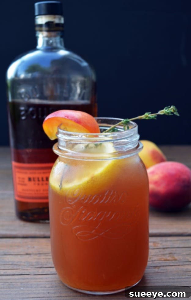 Southern Bourbon Peach Sweet Tea: A Spirited Summer Delight Bourbon Peach Sweet Tea served in a tall glass with fresh peach slices and mint.