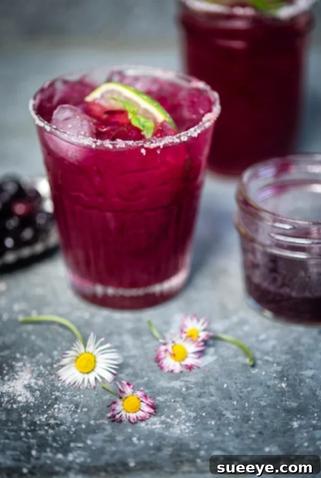 Unique Blueberry Basil Margarita: A Refreshing Herbal Cocktail Blueberry Basil Margarita in a glass, garnished with fresh blueberries and basil leaves.
