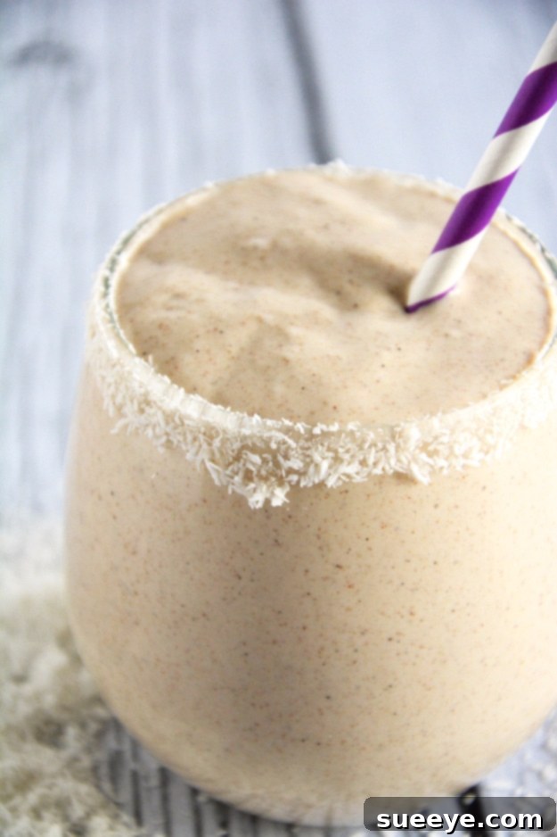 Energizing Almond Butter Smoothie: A Nutritious Power Drink Wholesome Almond Butter Smoothie in a glass jar, topped with almond slices.