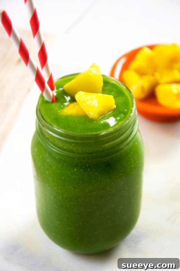 Hydrating Cucumber Tropical Green Smoothie: A Healthy Summer Treat Cucumber Tropical Green Smoothie in a glass, garnished with a cucumber slice.