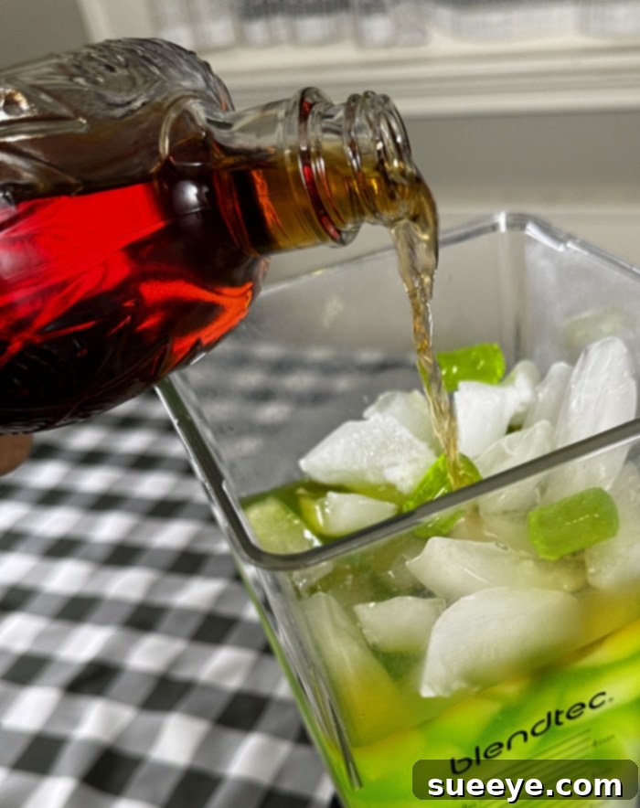 Rancher's Crown Royal Apple Slush 7 Pouring Crown Royal Apple whisky into a blender with other liquid ingredients