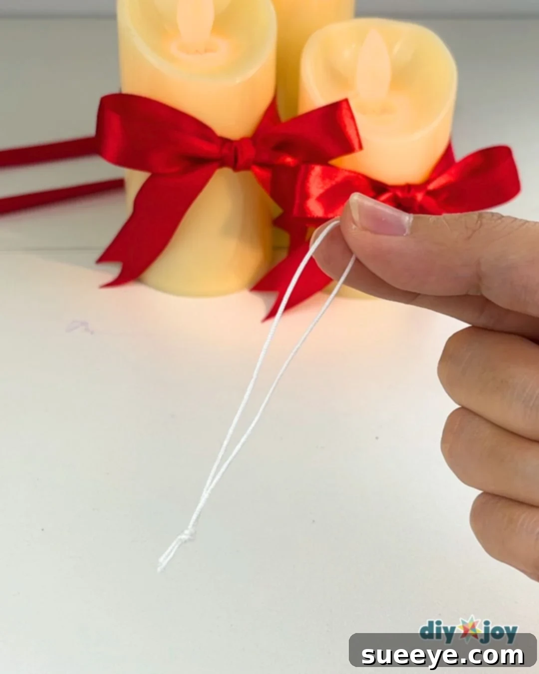 Make Easy Paper Christmas Ornaments 8 Classroom Christmas Decor - Tying a knot in a piece of string.