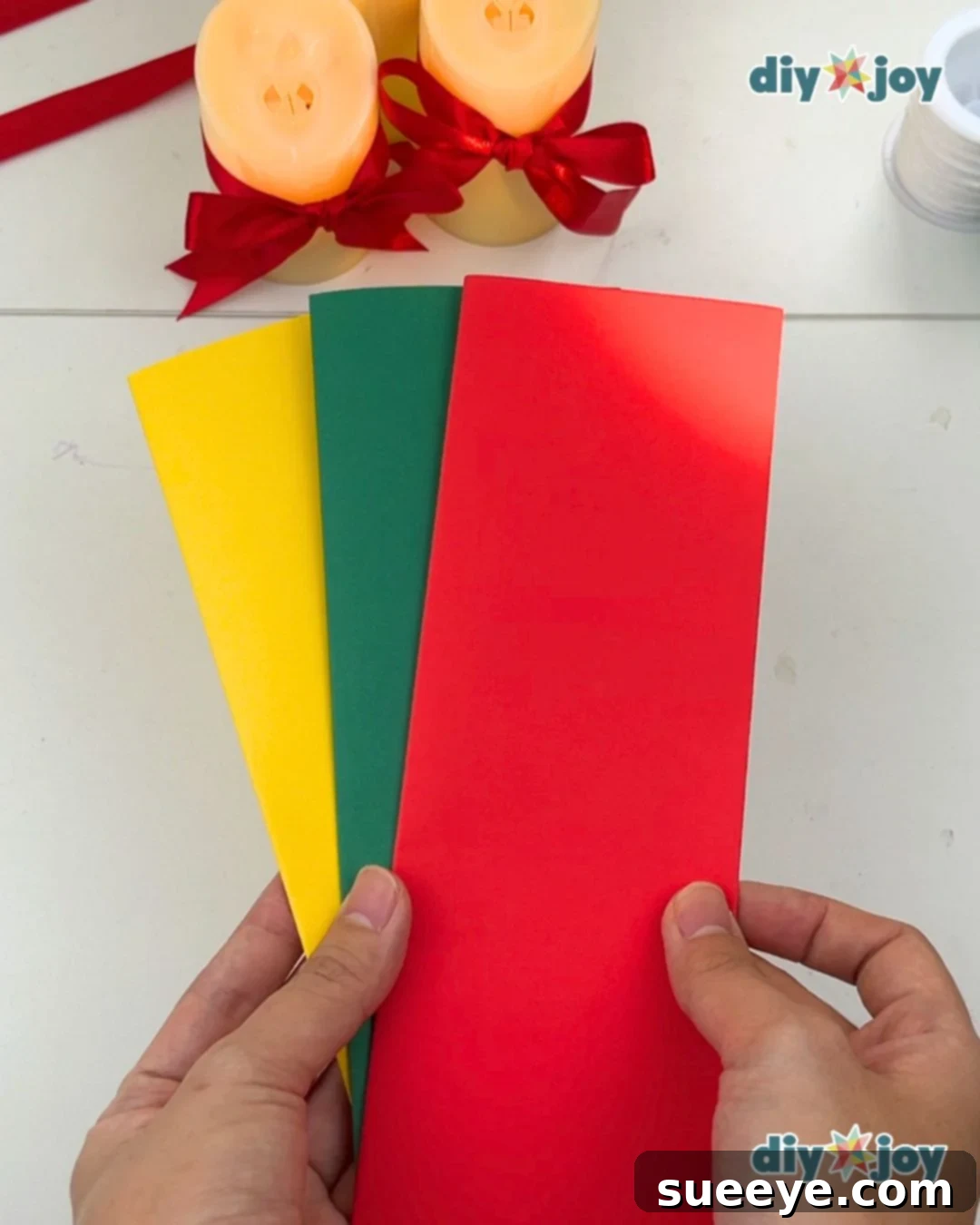 Make Easy Paper Christmas Ornaments 2 Paper Crafts - Hands demonstrating how to fold paper in half twice.