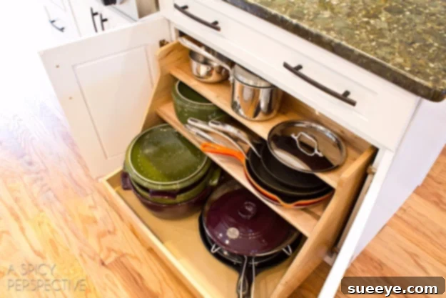 Roll-Out Cabinet Organizer Kitchen cabinet with a roll-out organizer for easy access to items.