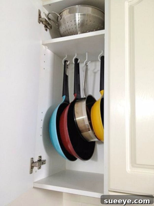 Tension Rod Pot Organizer Tension rods and shower hooks used as a DIY pot and pan organizer in a cabinet.