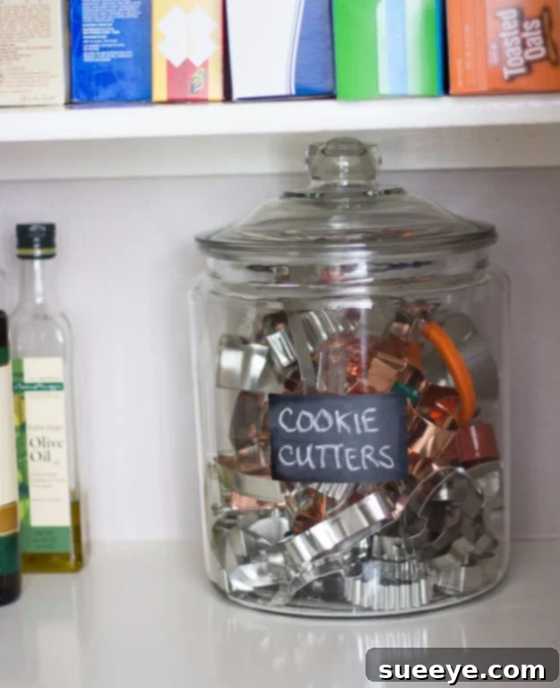 Cookie Cutter Storage Jar Cookie cutters neatly organized and stored upright in a clear glass jar.