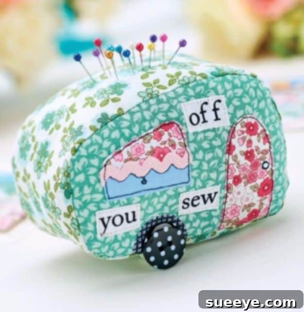 Whimsical stitched caravan pincushion made from colorful fabric scraps, shaped like a small trailer.