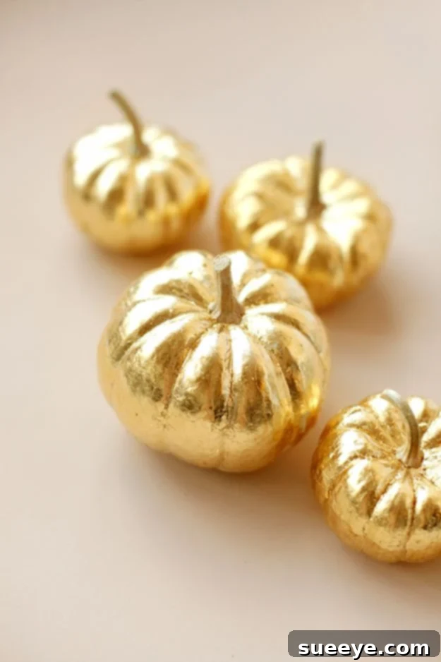 Gold Leaf Pumpkin White pumpkin adorned with shimmering gold leaf for elegant fall decor