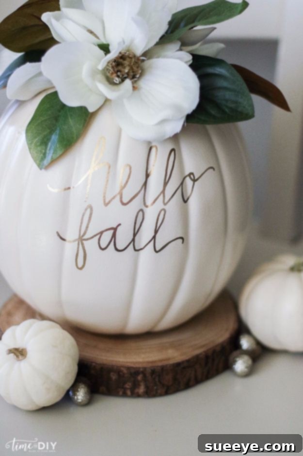 DIY Magnolia Pumpkin Faux pumpkin decorated with magnolia flowers and a gold holiday message