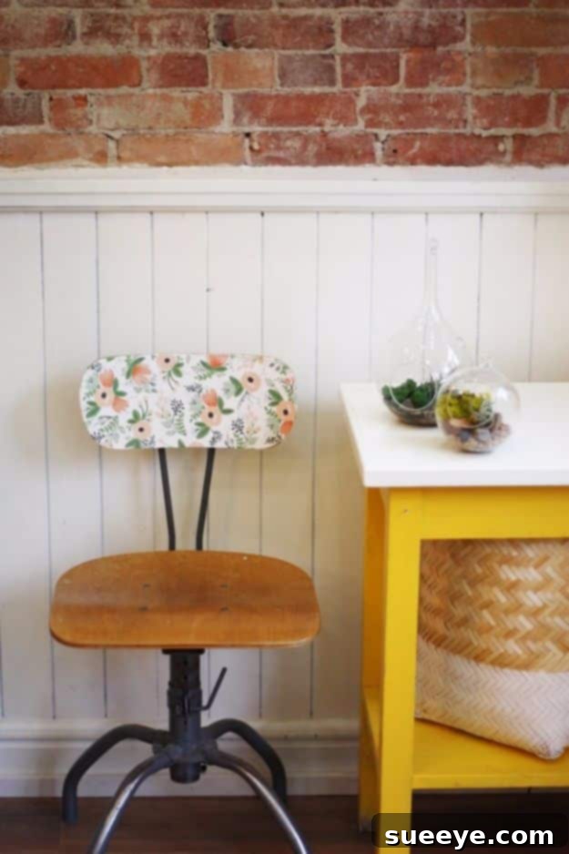 Vintage chair with a patterned wallpaper seat, a unique furniture upcycling idea.