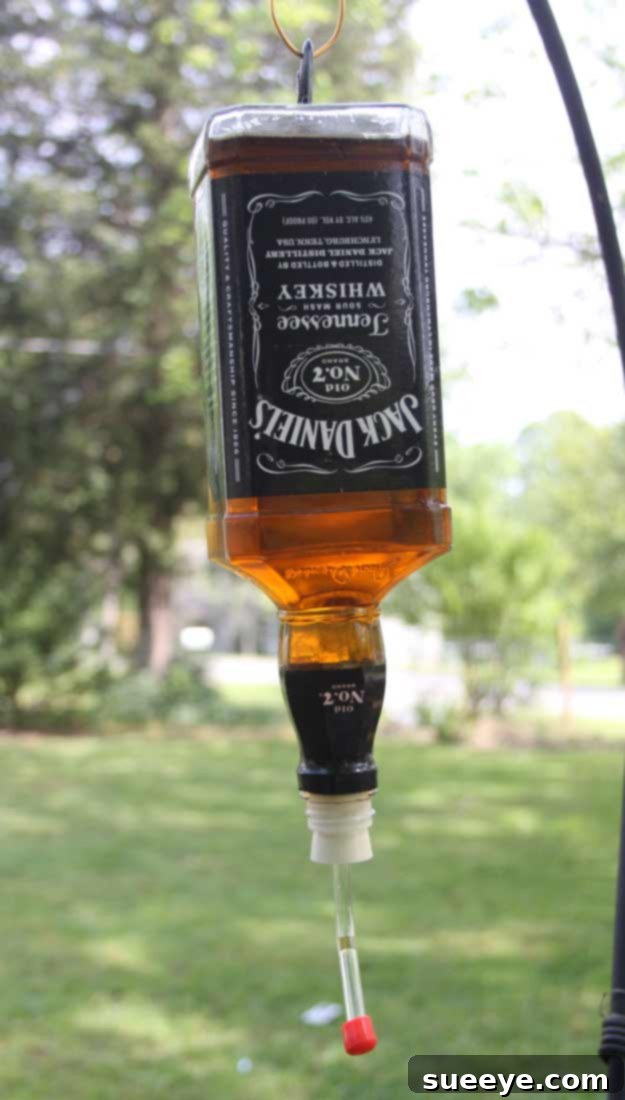 DIY Hummingbird Feeder from a Jack Daniel's Bottle: Attract Nature with Upcycled Decor Fun DIY Ideas Made With Jack Daniels - Recipes, Projects and Crafts With The Bottle, Everything From Lamps and Decorations to Fudge and Cupcakes | Humming Bird Feeder #diy #jackdaniels #recipes #crafts