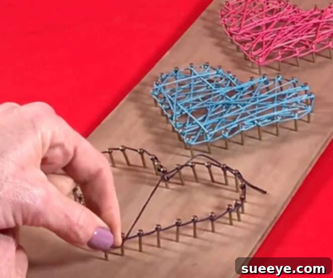 3 Beginner-Friendly String Art Projects 5 A finished string art heart on a wooden plank