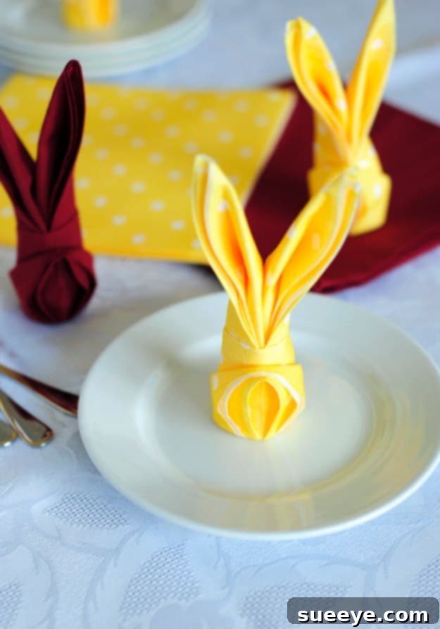 48 Creative DIY Easter Decor Projects 35 A neatly folded cloth napkin shaped into an Easter bunny, used as a decorative place setting.