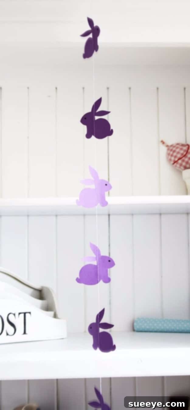 48 Creative DIY Easter Decor Projects 48 A charming garland of cutout rabbits strung together, creating a playful Easter decoration.