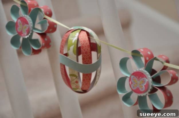 48 Creative DIY Easter Decor Projects 7 A delicate garland featuring paper flowers and Easter eggs in pastel colors.
