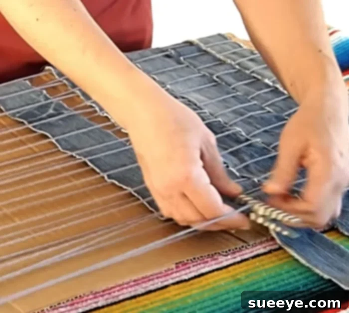 Transform Old Denim Into A Cozy Rug 3 Closer view of the denim rug weaving, showing detailed intertwining of denim strips and yarn
