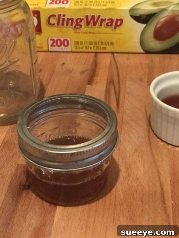 Banish Fruit Flies For Good 5 A completed mason jar DIY fruit fly trap, a natural and effective solution for combating fruit fly infestations in the kitchen.