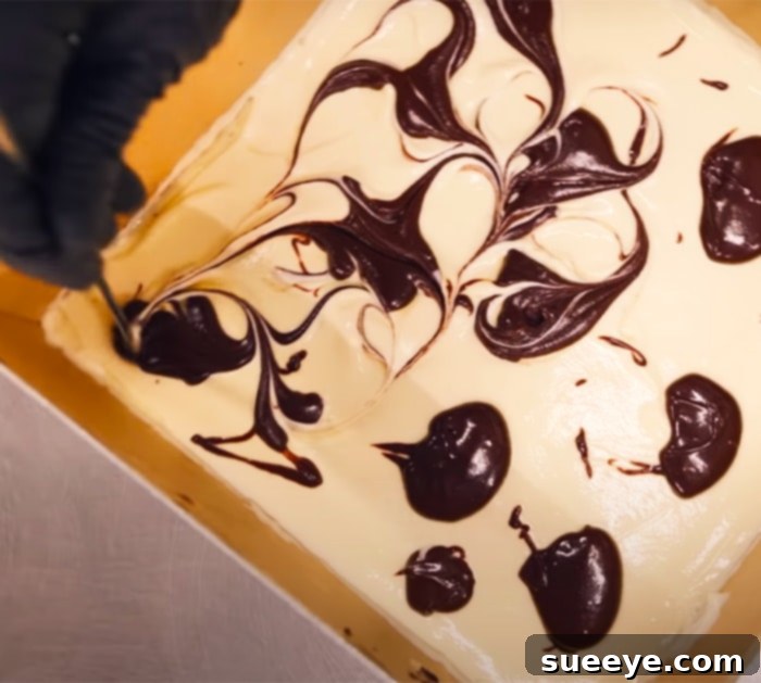 Achieve the signature marble effect by swirling dollops of brownie batter into the creamy cheesecake layer before baking.