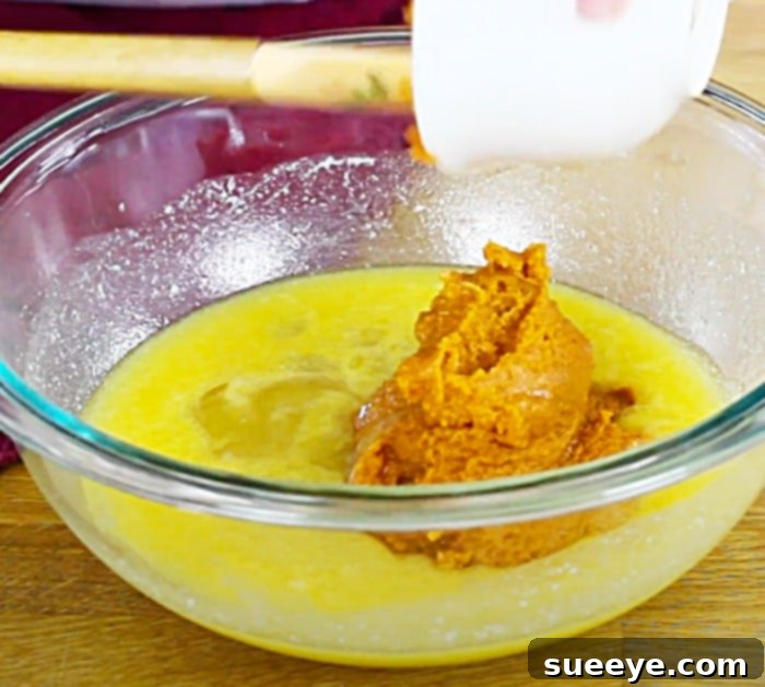 Sweet Glazed Pumpkin Streusel Muffins 2 Homemade pumpkin muffin batter being prepared for baking with a spatula in a bowl