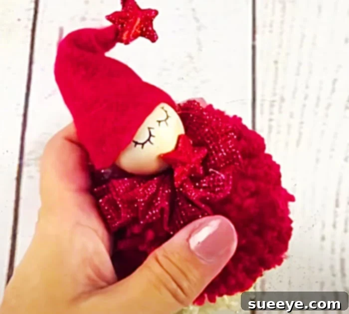 This image captures another exquisitely detailed pom-pom angel, showcasing unique embellishments and inspiring various design possibilities for DIY Christmas decorations and yarn craft enthusiasts.