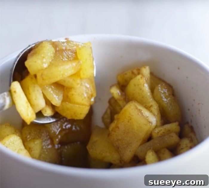 Quick Apple Pie Mug Bliss 2 How To Make Apple Pie In A Mug - 5 Minute Recipes - Healthy Recipes: A close-up of the apple pie batter being mixed in a bowl, with fresh apple slices nearby, ready for assembly into a mug.