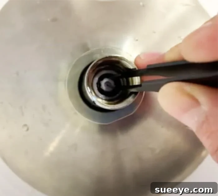 Boost Your Shower Pressure 2 How to Increase water pressure - Shower head water pressure - DIY Bathroom. An image showing a hand detaching a shower head.